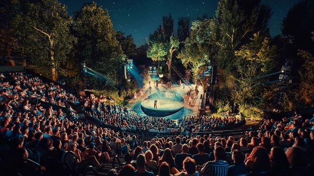 The Open Air Theatre in Regent's Park is filled with spectators at night watching one of the performances programmed.