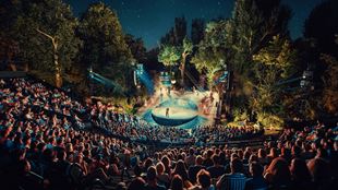 The Open Air Theatre in Regent's Park is filled with spectators at night watching one of the performances programmed.