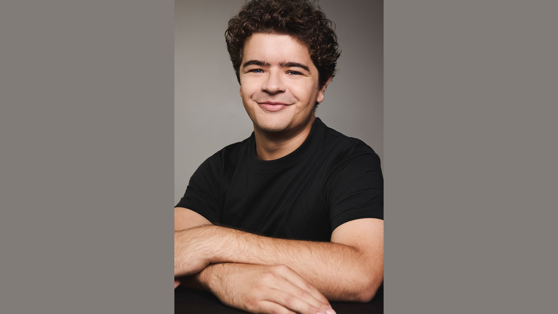 Celebrate the 30th anniversary of the highly anticipated revival of RENT the Musical, starring Gaten Matarazzo, at the Duke of York's Theatre. Photo credit: Victoria Stevens. A portrait of Gaten Matarazzo wearing a black T-shirt, used to announce his casting in Rent.