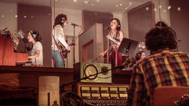 Three band members are recording in the studios as part of the stage production of Stereophonic.