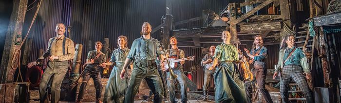 The West End cast of The Curious Case of Benjamin Button dance on a stage decorated to look like a barn.