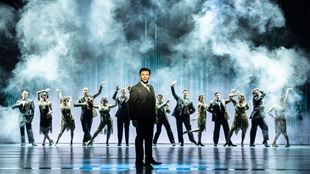 Corbin Bleu as Nick Carraway in The Great Gatsby, framed by smoke effects and the cast.