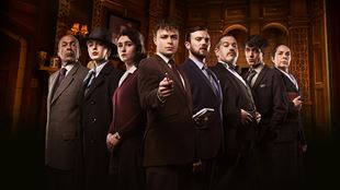 La troupe de The Mousetrap, une pièce écrite par Aatha Christie, regarde l'objectif de facon mystérieuse avec le Sergent Trotter au centre pointant du doigt le spectacteur.