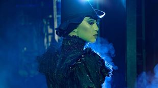 Elphaba, la méchante sorcière de l'Ouest, est représentée regardant de côté, portant un chapeau de sorcière noir et une robe noire.