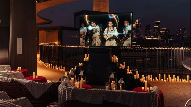 Screen showing Ghostbusters at a rooftop with candles and sofas