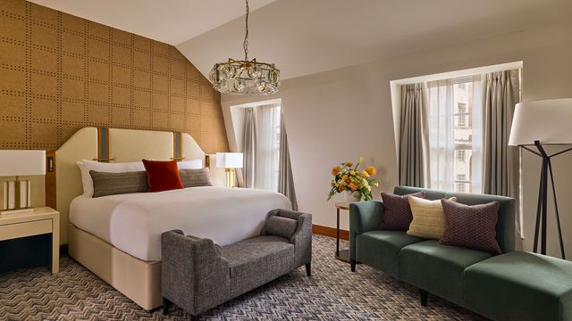 The elegant interior of a bedroom with a window and furniture at the Conrad London St James hotel