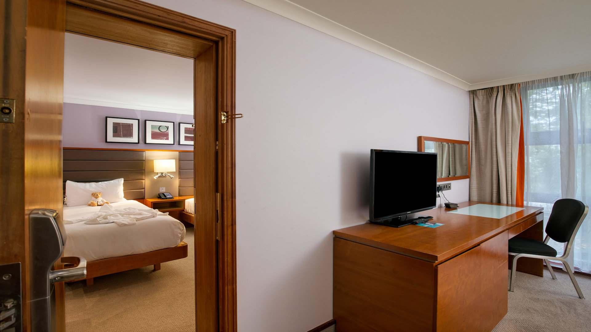 Family bedroom with interconnecting rooms, desk and television in one room, child's bedroom in the other room