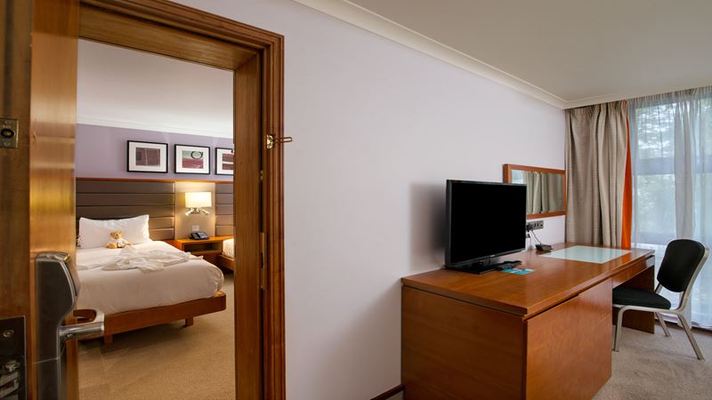 Hilton London Kensington family room. Image courtesy of Hilton. Family bedroom with interconnecting rooms, desk and television in one room, child's bedroom in the other room