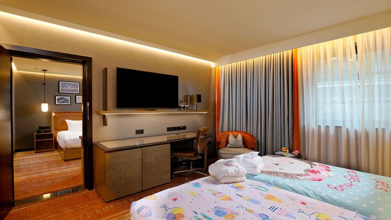 Hilton London Tower Bridge family room. Image courtesy of Hilton. Family hotel bedroom, with two beds and children's bedding, television on the wall and chest of drawers