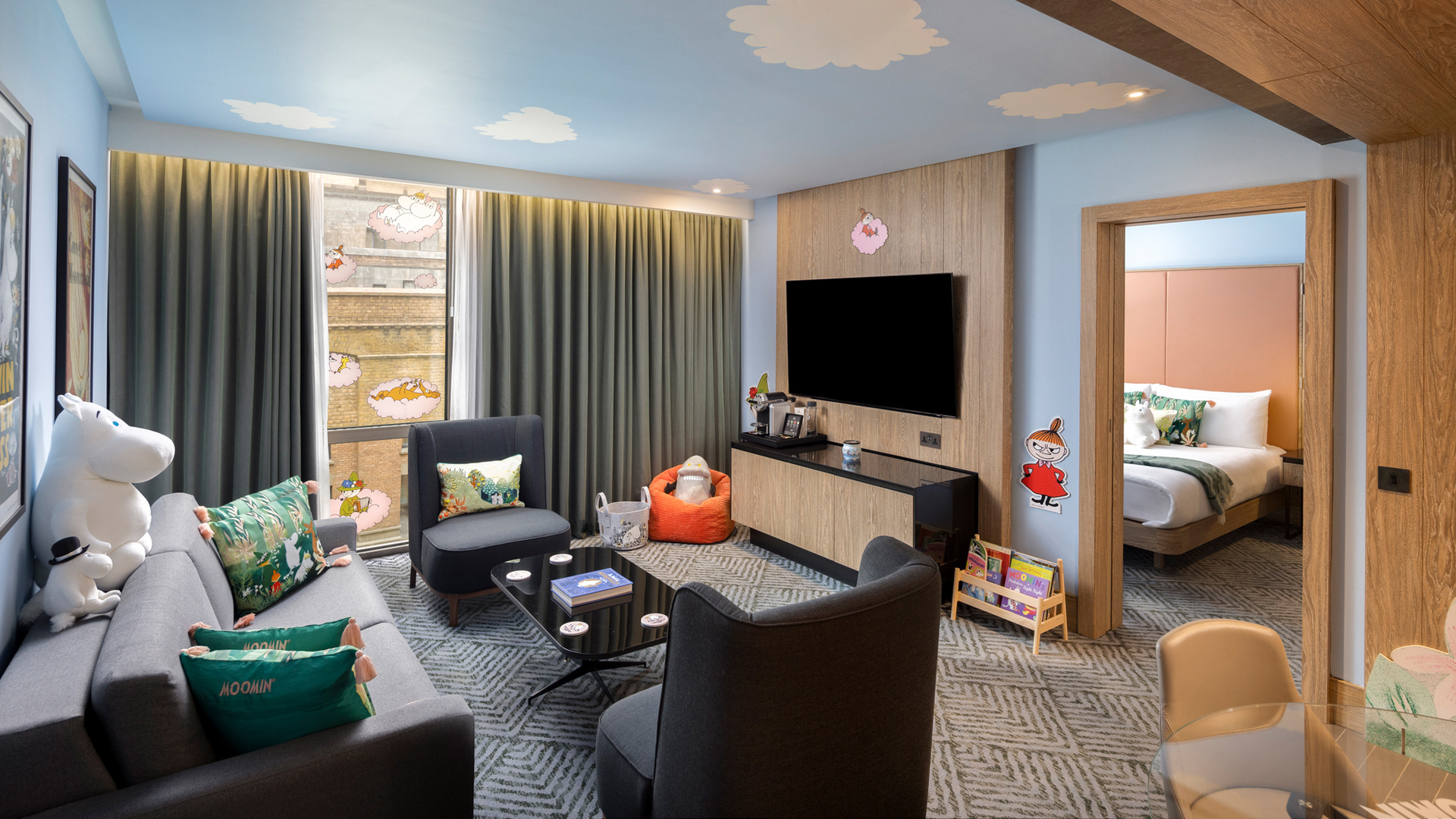 A hotel room featuring Moomin toys and clouds painted on the ceiiing