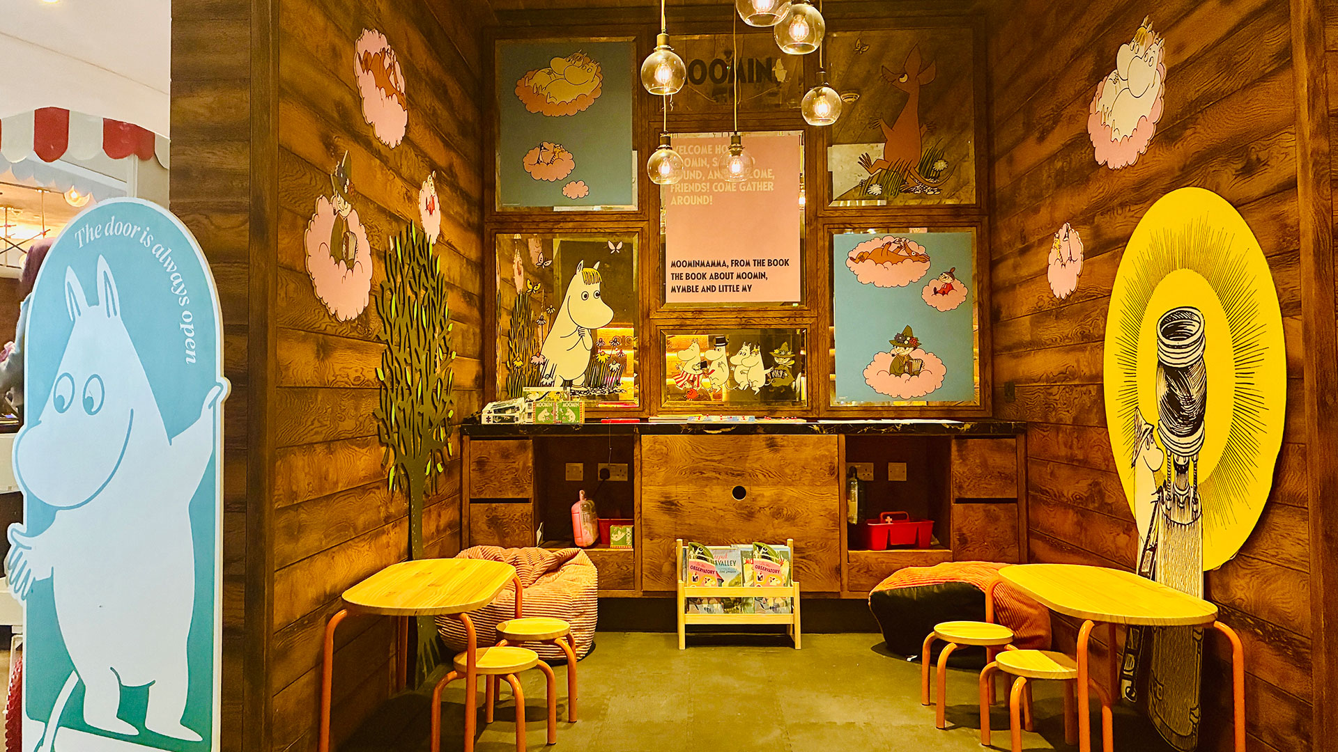 A Moomin-themed play area featuring tables, stools, books and toys