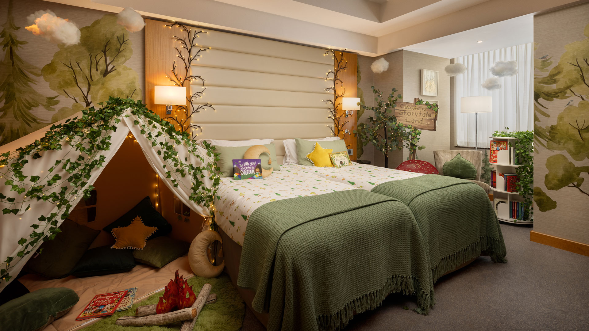 Séjournez dans une chambre digne d'un conte de fées au Conrad London St. James Family Experience. Avec l'aimable autorisation de Hilton. Chambre décorée de façon féerique avec du lierre, une tente et un livre posé sur l'un des lits au Conrad London St James.