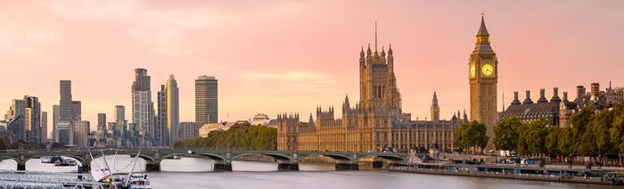 Vue sur Big Ben et les Maisons du Parlement bordant le fleuve de la Tamise pendant le coucher de soleil.
