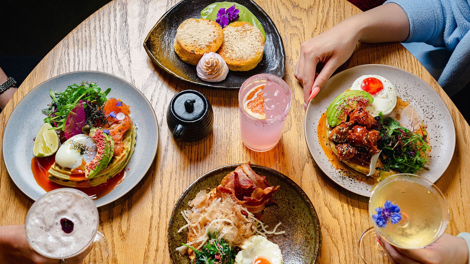 Four plates on a table serving a cooked breakfast