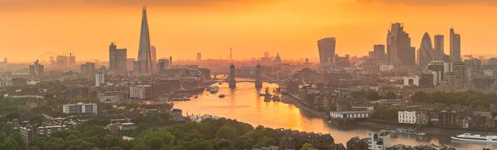 Vue sur Londres au coucher du soleil, avec le Shard et Canary Wharf visible le long de la ligne d'horizon.