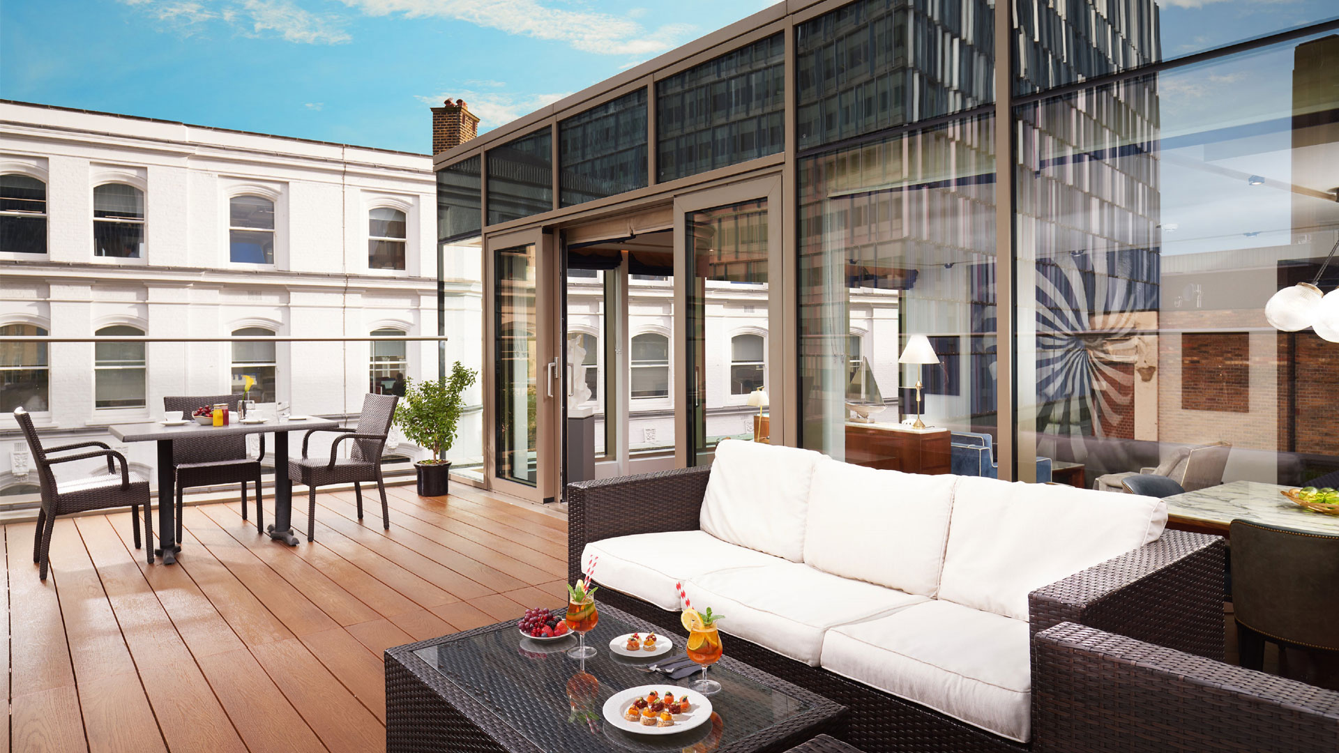 L'une des suites de l'hotel Hilton London Bankside avec sa terrace extérieure équippée d'un sofa blanc et d'une table.