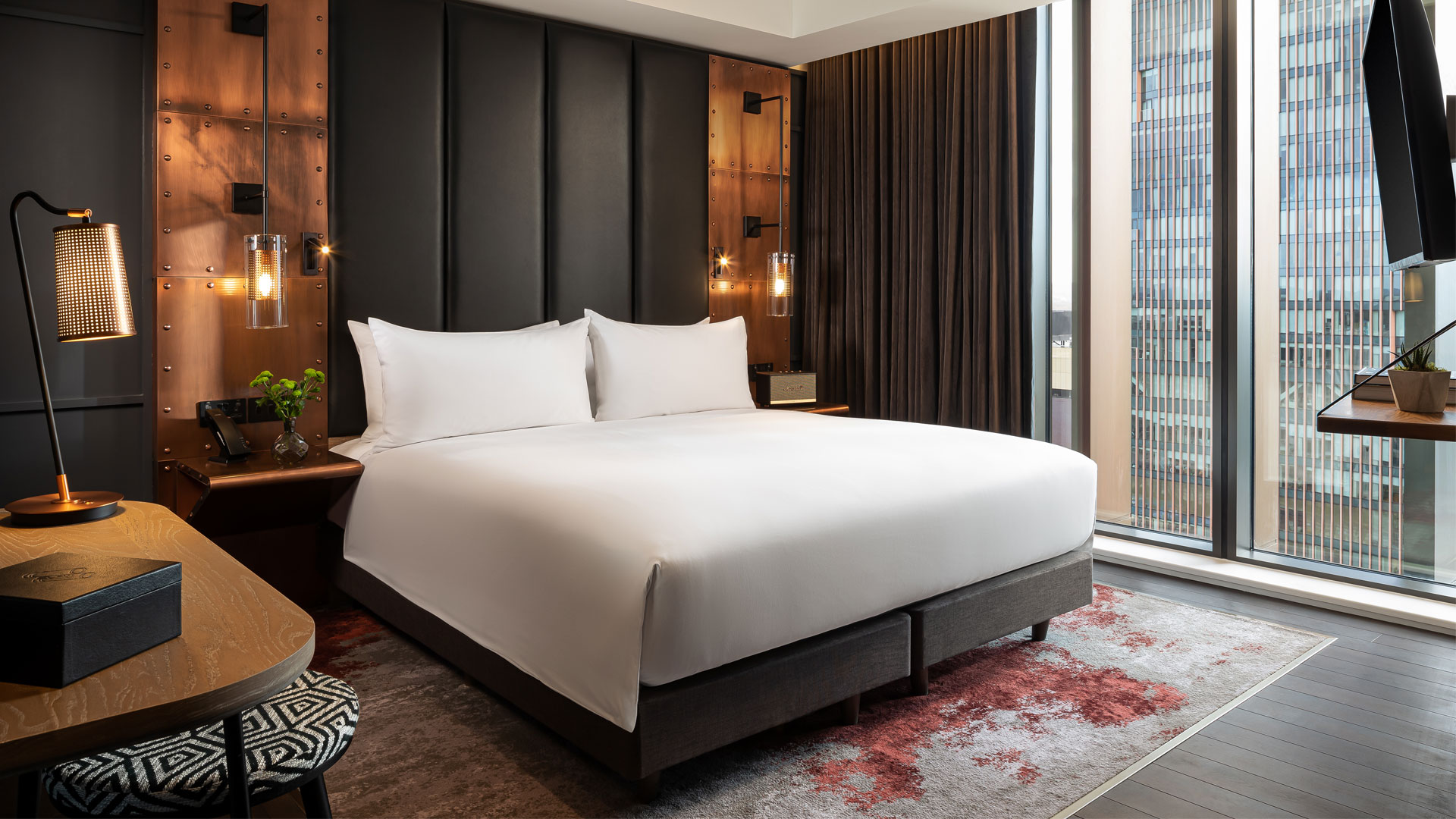 Chambre faisant partie d'une suite de l'hotel The Gantry London, aux tons marrons et or. 