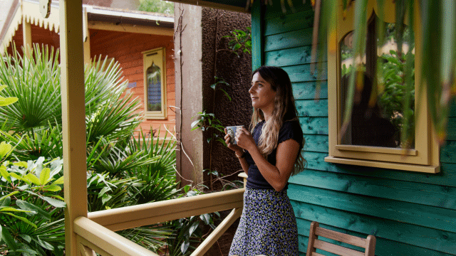 Woman sipping on a morning coffee at London Zoo Lodges