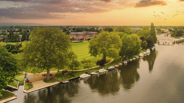 Aerial view of The Lensbury hotel surrounded by green lawns, trees and the river Thames