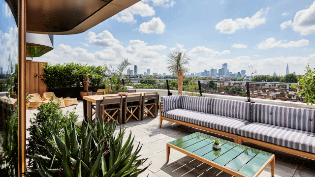 Sun shines on the rooftop at The Standard with sofa, chairs and plants