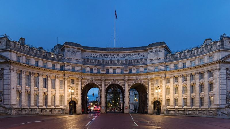 Admiralty Arch illuminated at dusk, linking Trafalgar Square with The Mall. Image courtesy of Luchford. Photo credit: David Illiff. Admiralty Arch in London illuminated at dusk, with the central archway opening onto The Mall.